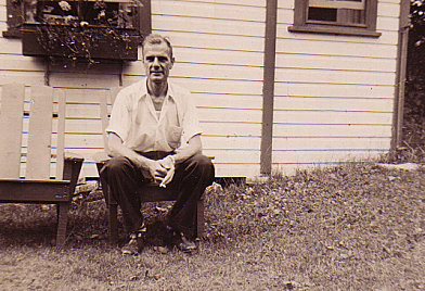 Brother Tony by a wooden house
